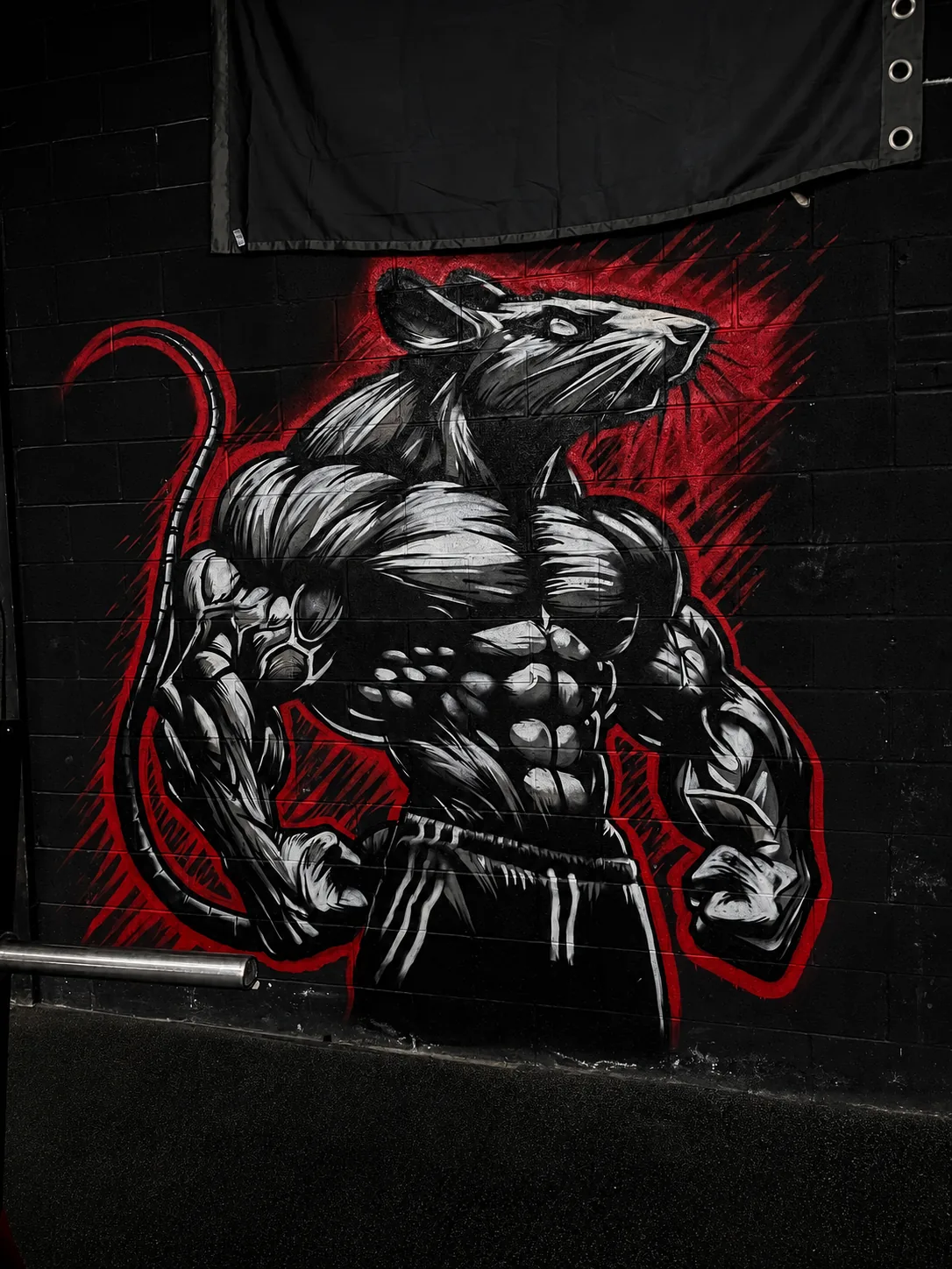 Muscular gym rat character mural, black wall with red accents