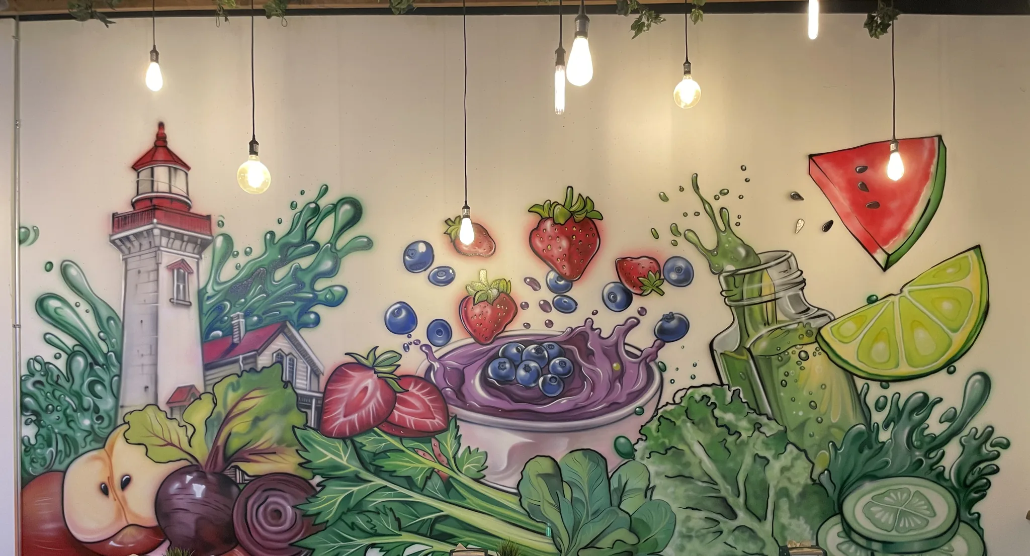 Café mural of oversized fruit and vegetables mid-splash with a lighthouse