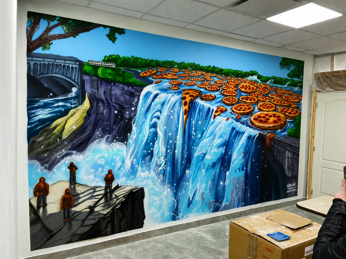 Pizza waterfall mural — pizza slices cascading over a falls with onlookers