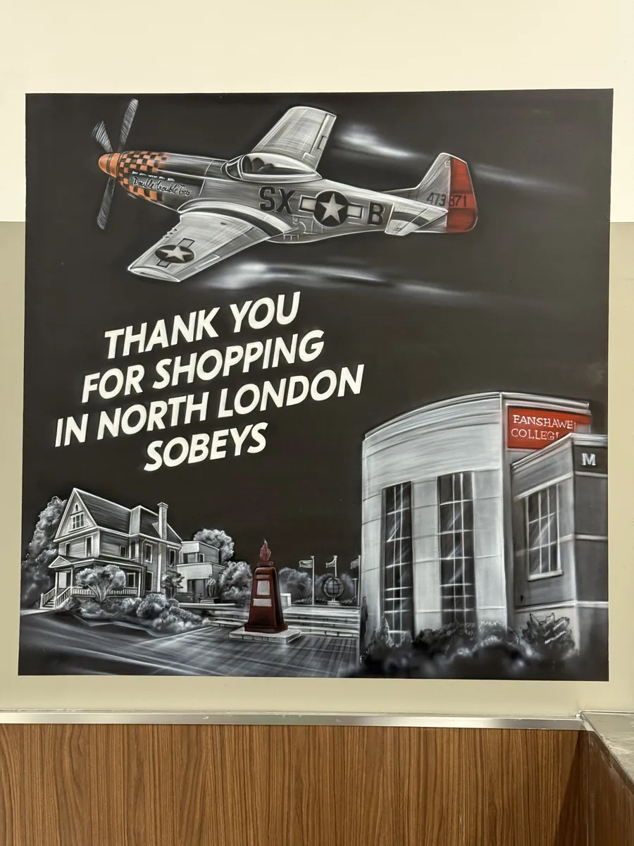 North London Sobeys mural — greyscale WWII fighter plane over a streetscape