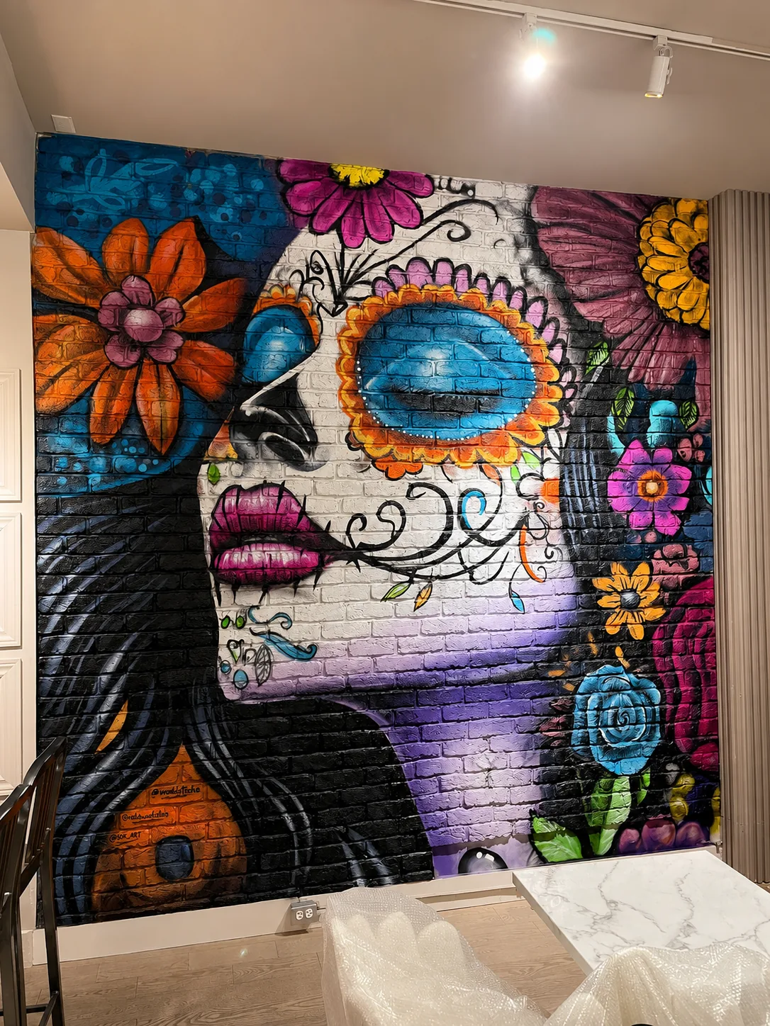 Sugar-skull woman with florals on white brick